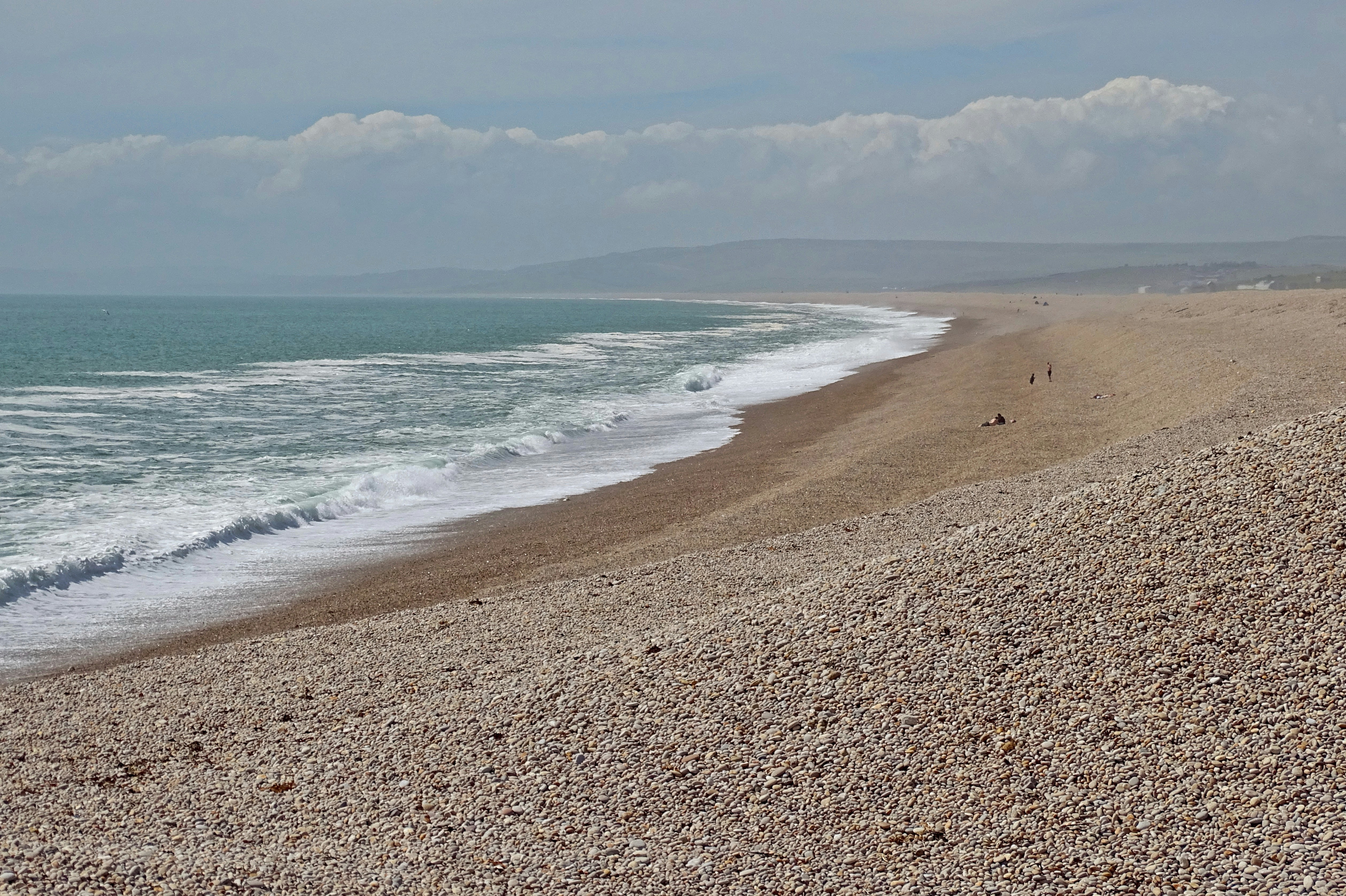 a beach with a few people walking on it