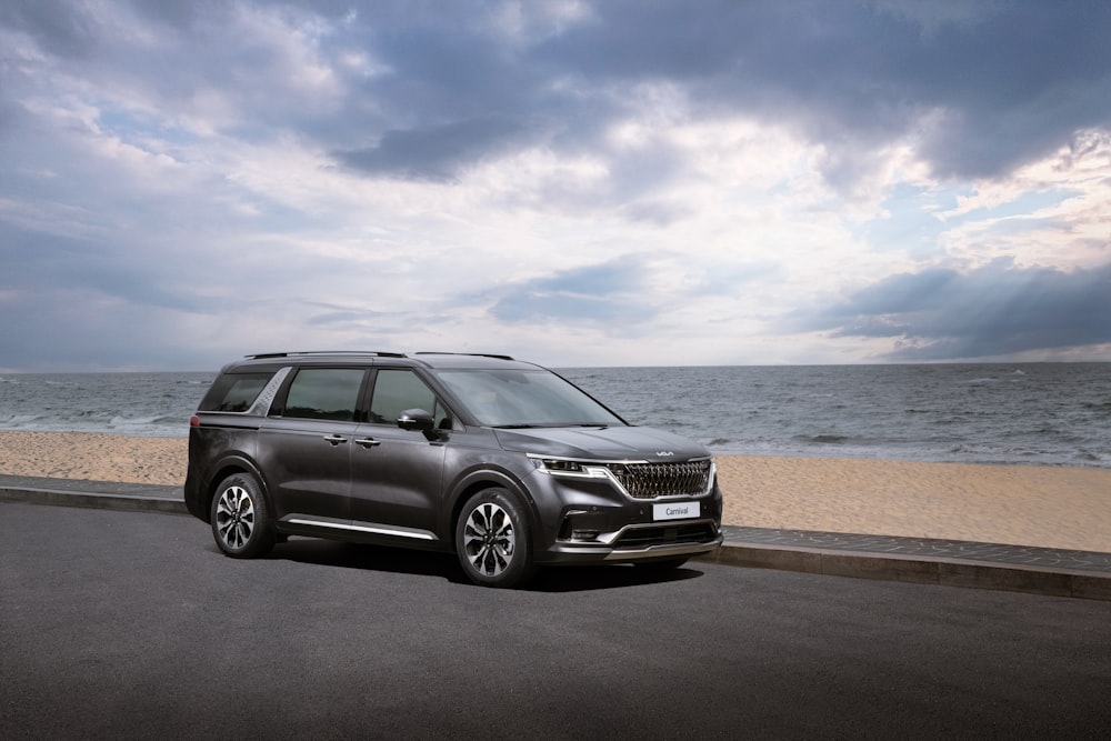 a grey suv parked on the side of a road near the ocean