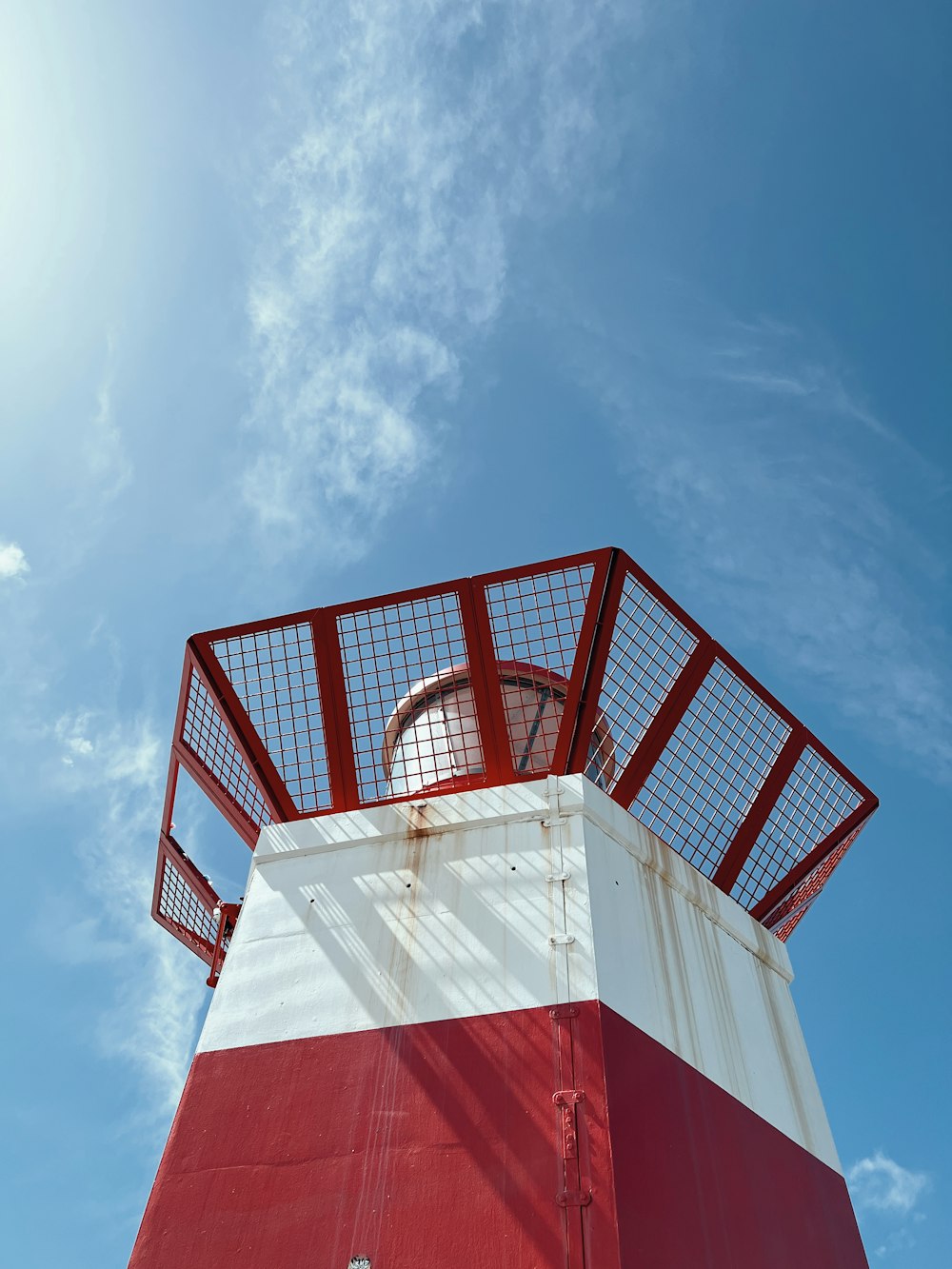 a red and white lighthouse under a blue sky