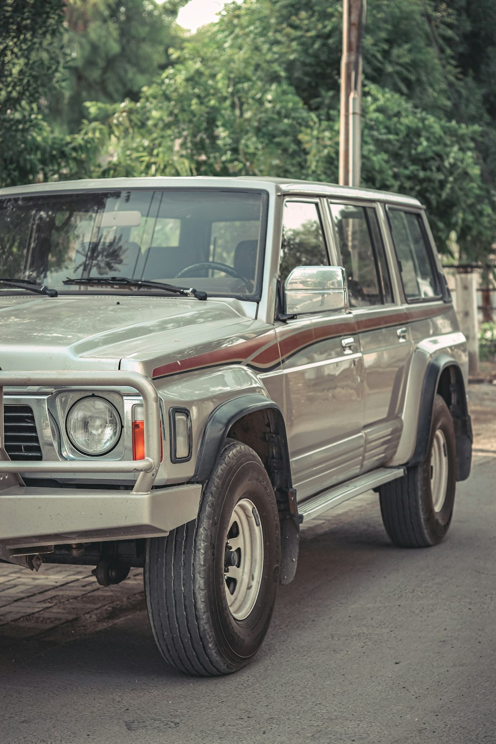 a silver jeep parked on the side of a road