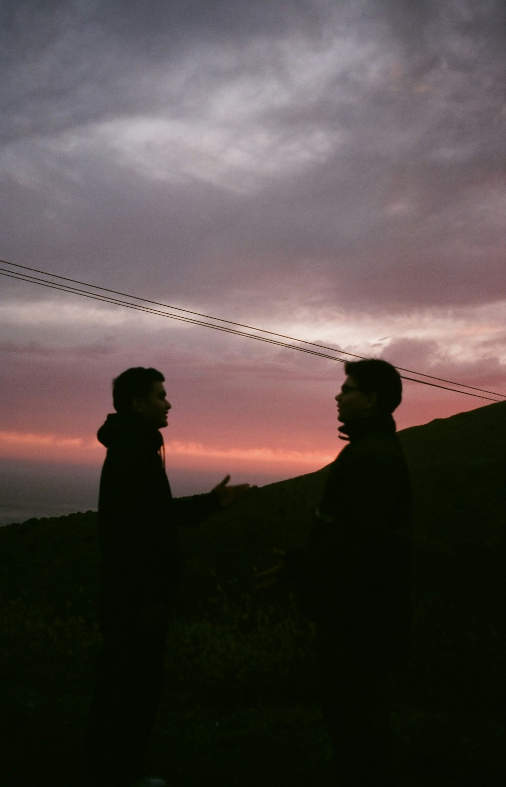 a couple of men standing next to each other under a cloudy sky