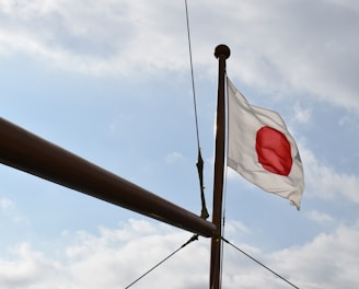 a white and red flag flying on top of a pole