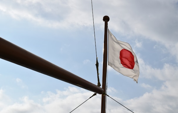 a white and red flag flying on top of a pole