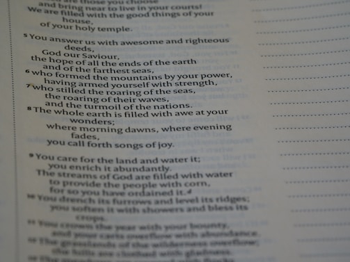 The image displays a page of printed text, likely from a religious or poetic work. The text includes numbered lines and discusses themes such as the power of God, nature, and creation. The right side of the page has a series of dotted lines running vertically.