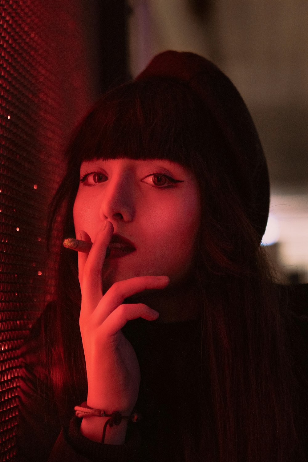 a woman smoking a cigarette in a dark room
