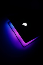 a close up of an apple laptop in the dark