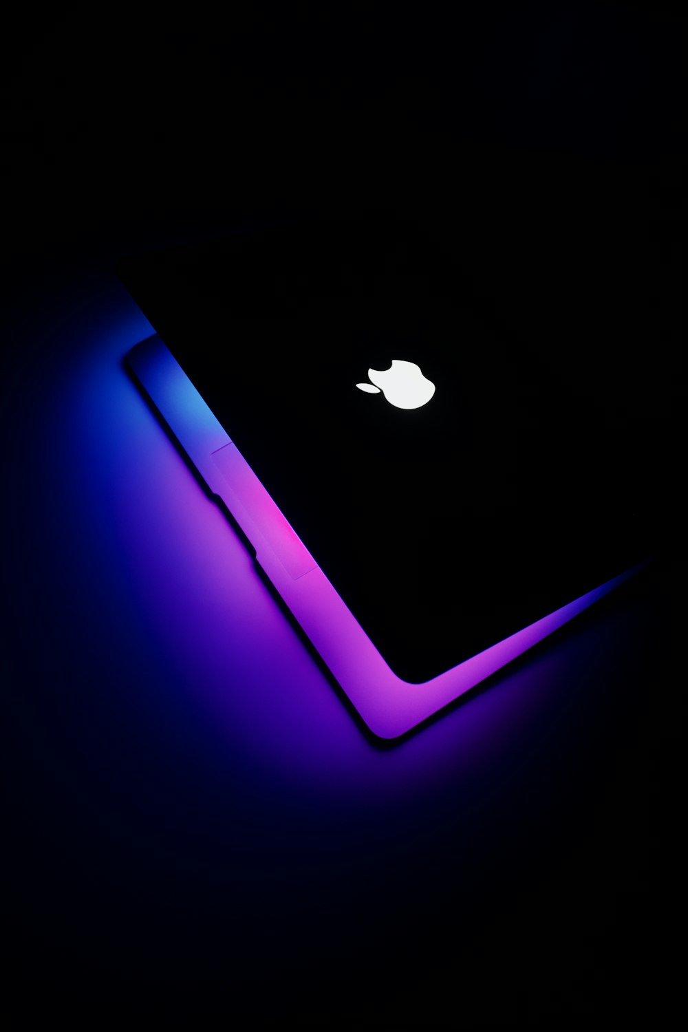 a close up of an apple laptop in the dark