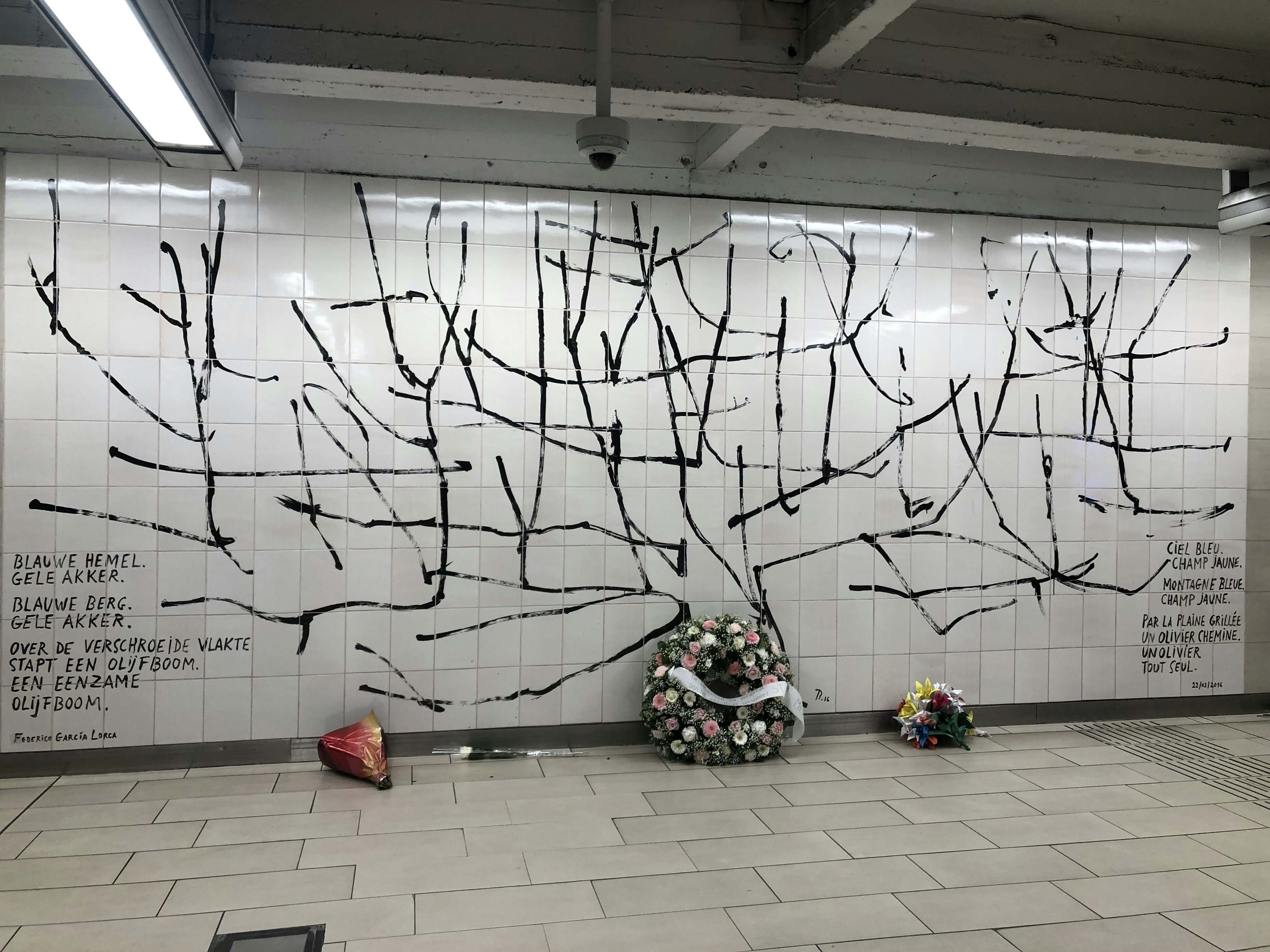 a white tiled wall with a painting on it