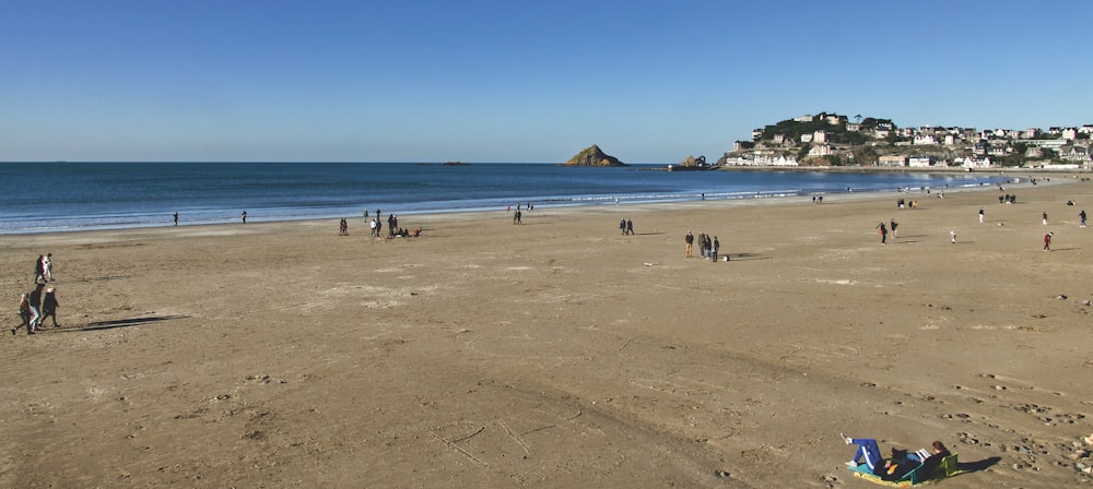 a group of people standing on top of a sandy beach