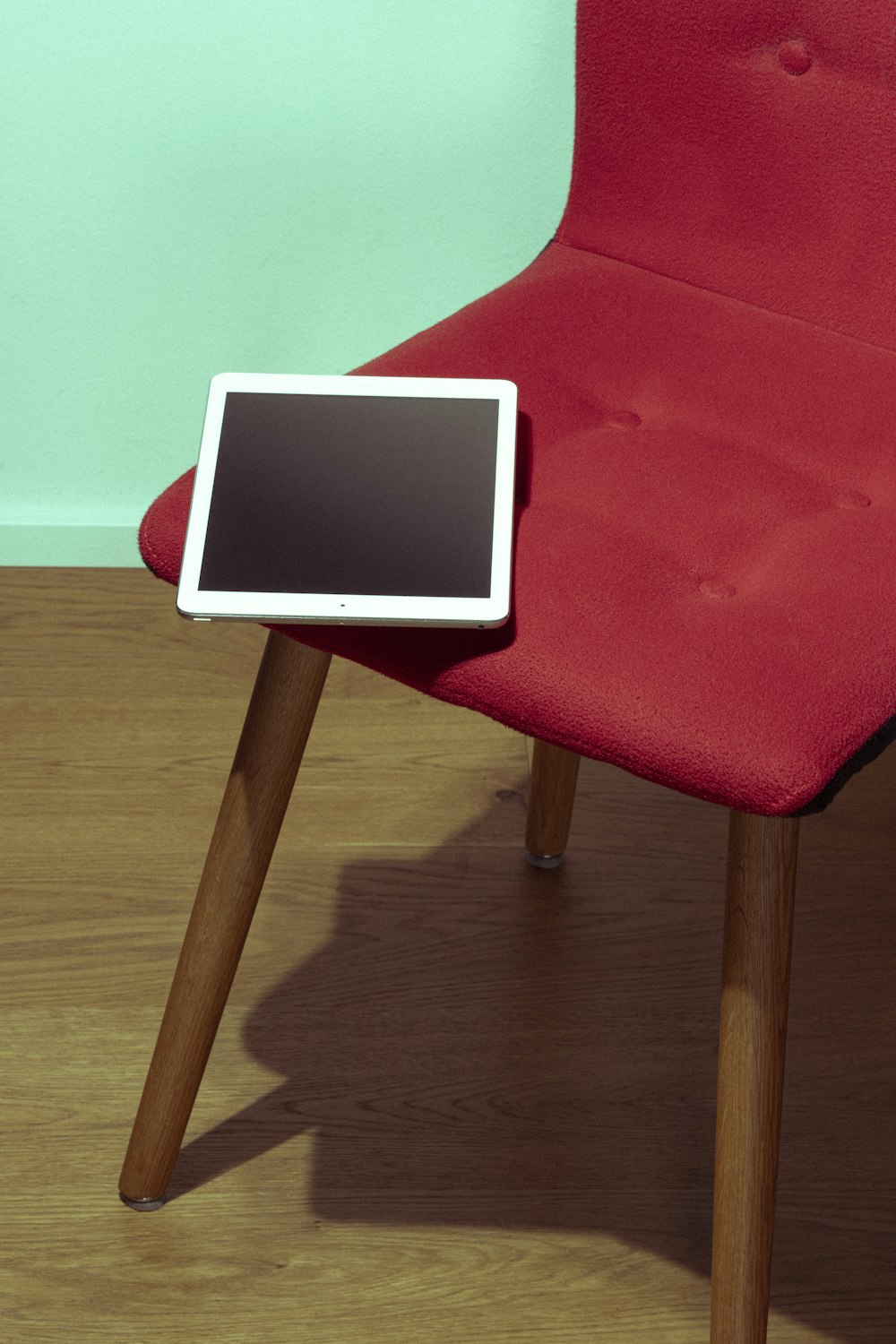 a red chair with a tablet on top of it