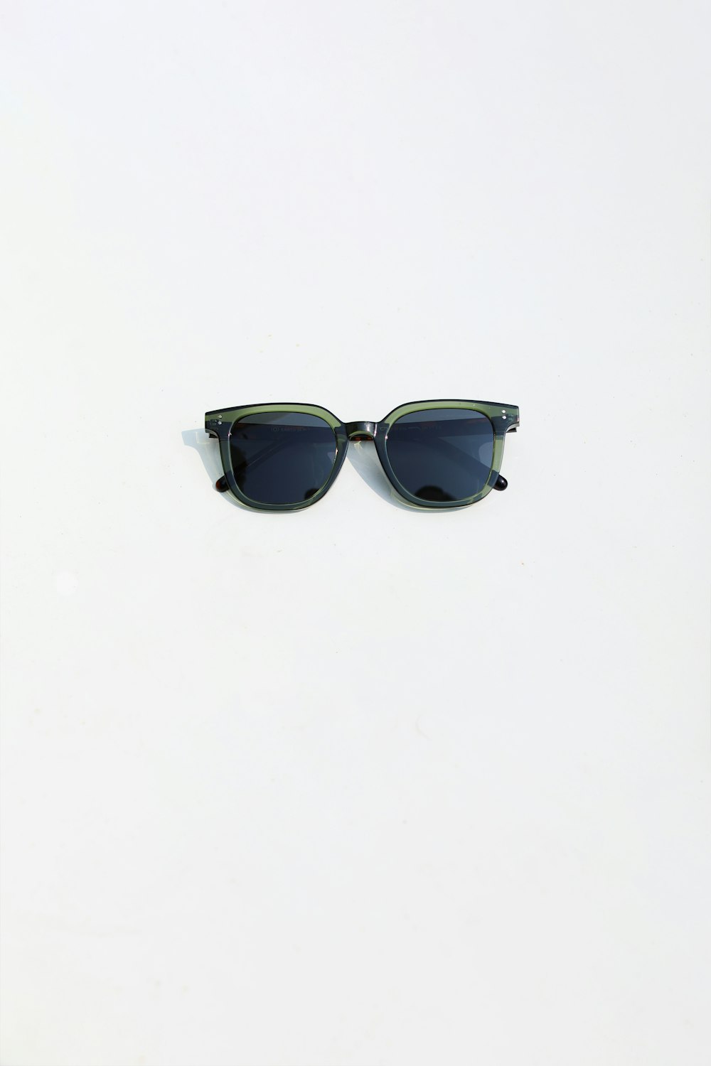 a pair of sunglasses sitting on top of a white surface