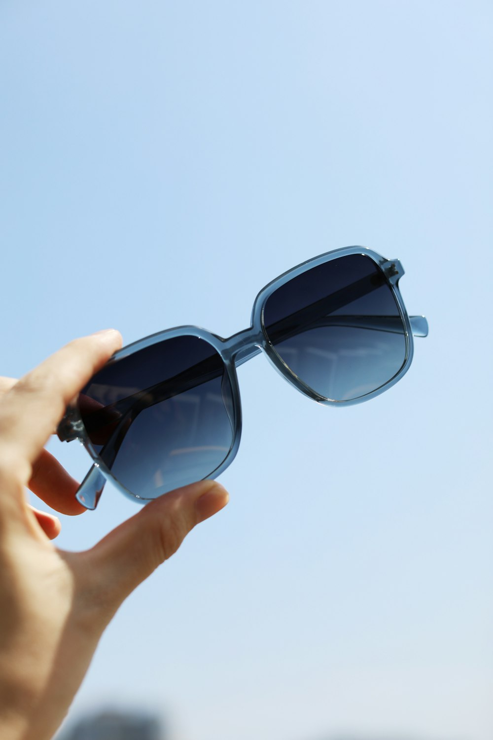 a person holding a pair of sunglasses in their hand