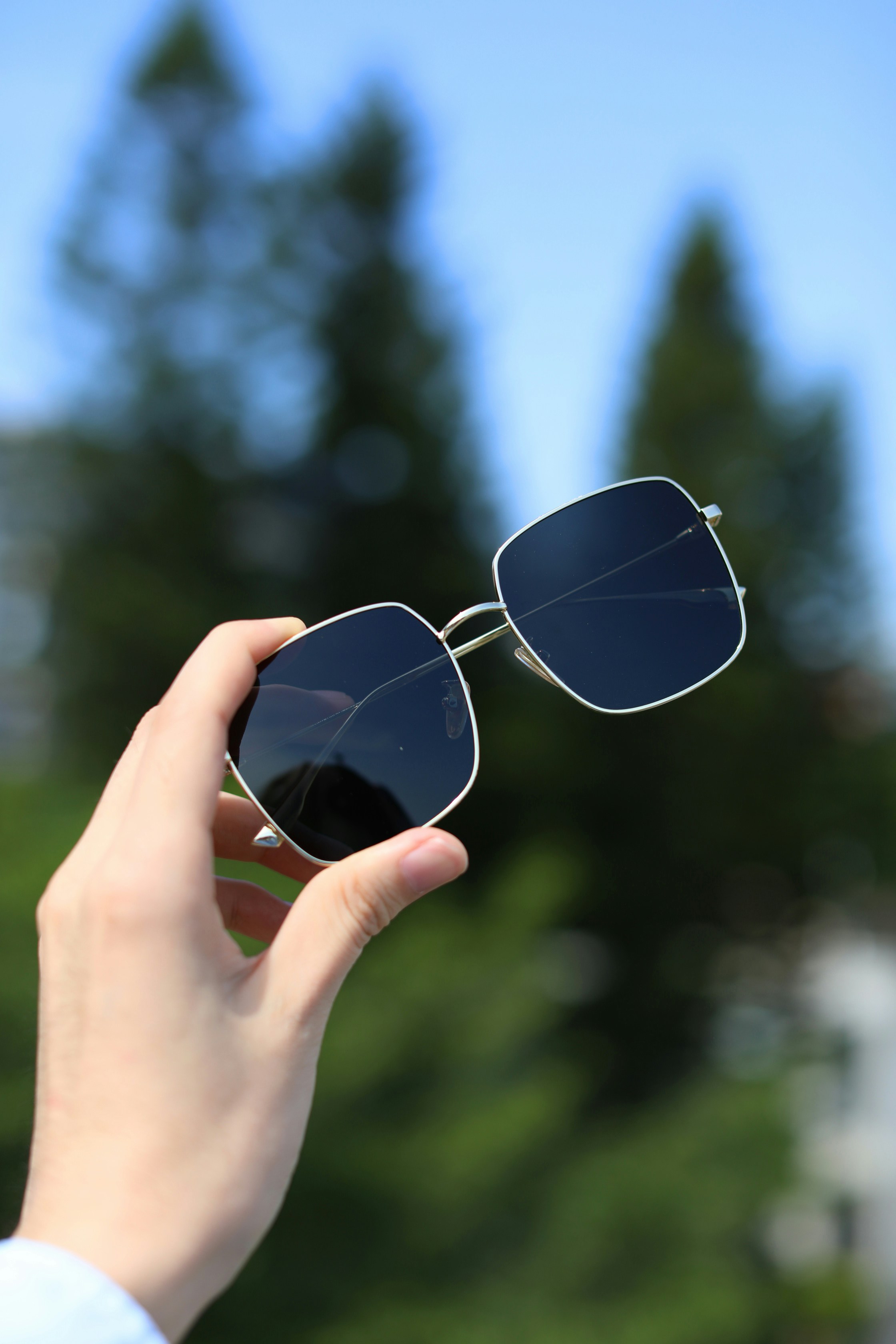a person holding a pair of sunglasses in their hand