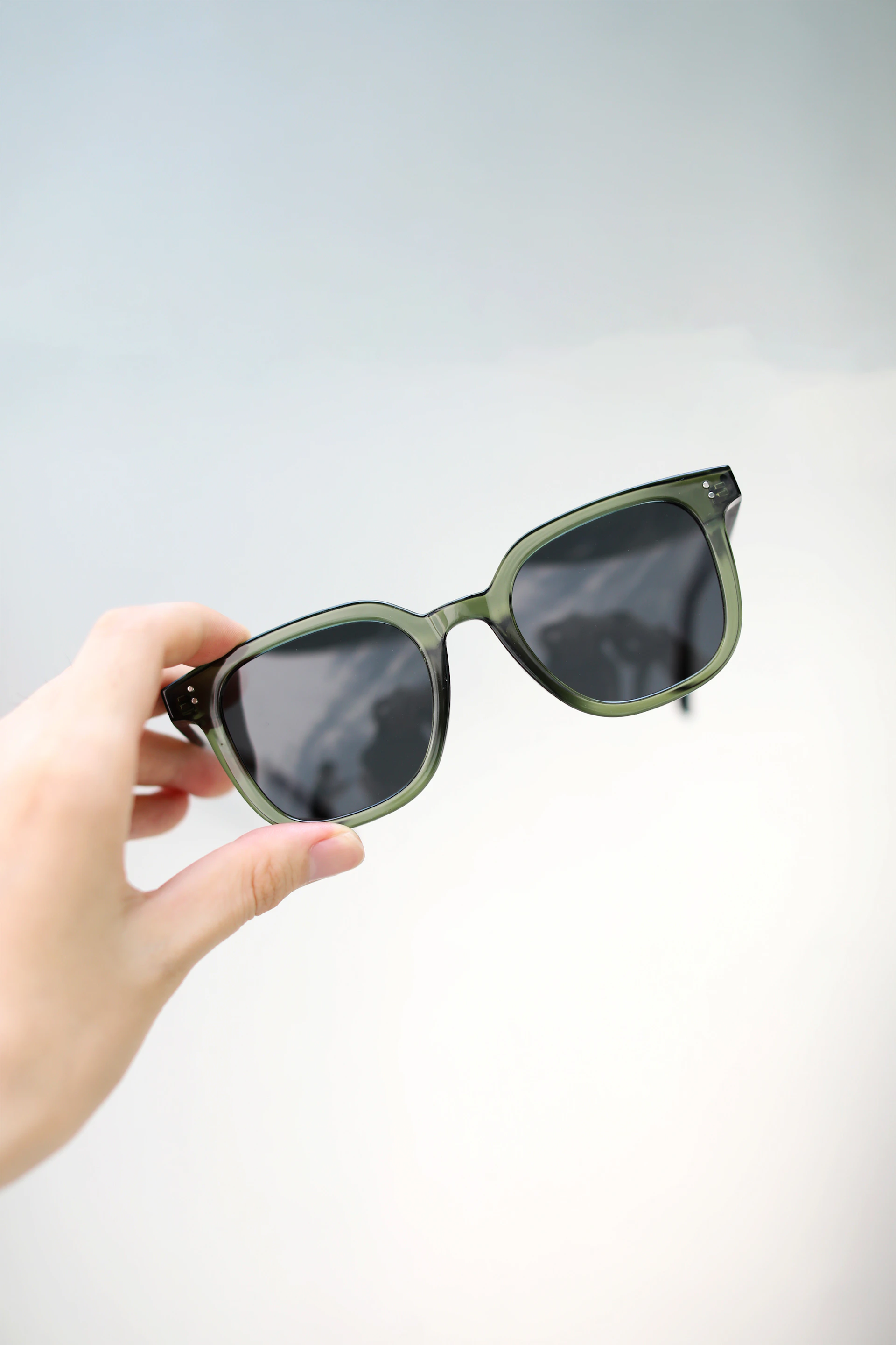 a person holding a pair of sunglasses in their hand