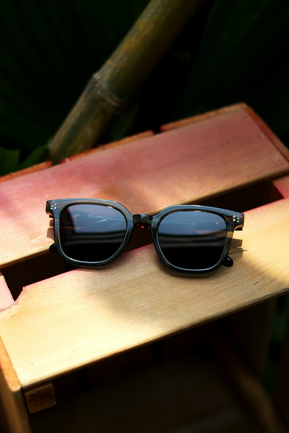 a pair of sunglasses sitting on top of a wooden table