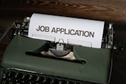 a typewriter with a job application printed on it