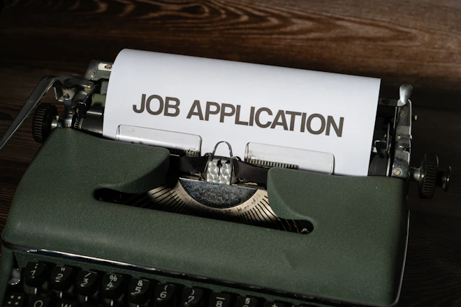 a typewriter with a job application printed on it
