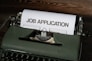 a typewriter with a job application printed on it