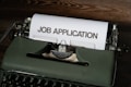 a typewriter with a job application printed on it