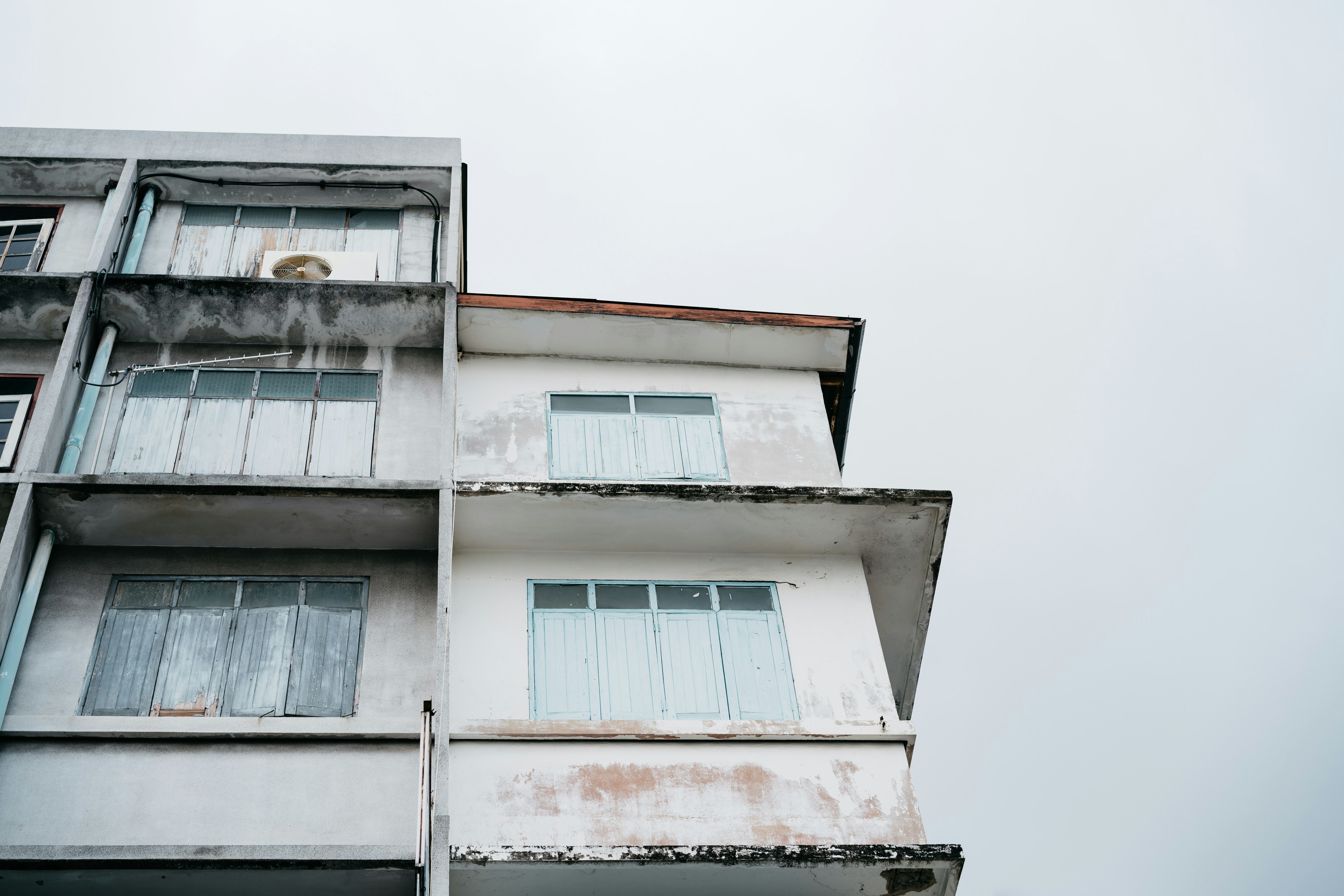 a tall white building with windows and balconies