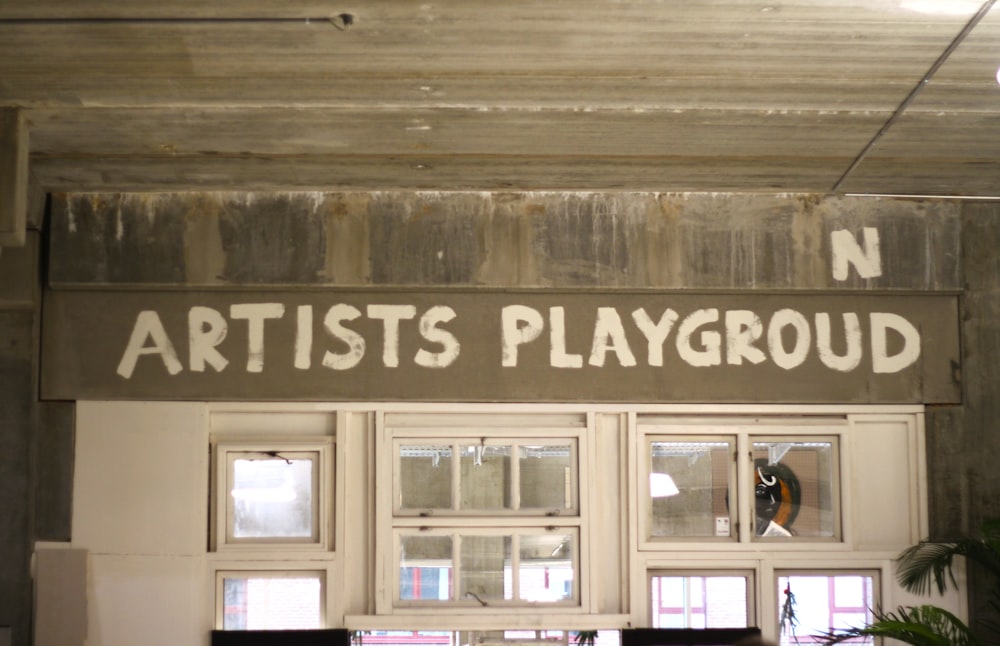 Un cartello che recita il parco giochi degli artisti su un muro
