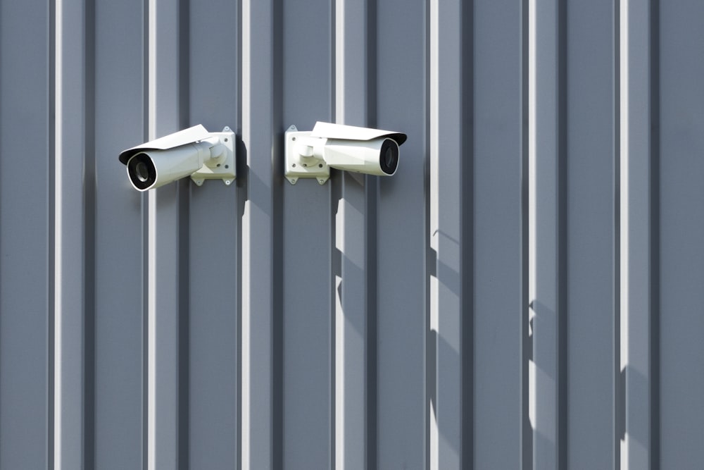 two cameras mounted to the side of a building