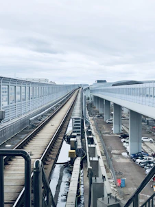 A professional team installing safety barriers along railway tracks during a construction project on a sunny day.