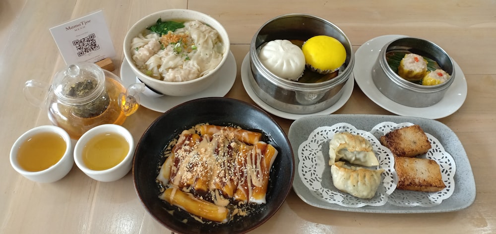 a table topped with plates of food and bowls of soup