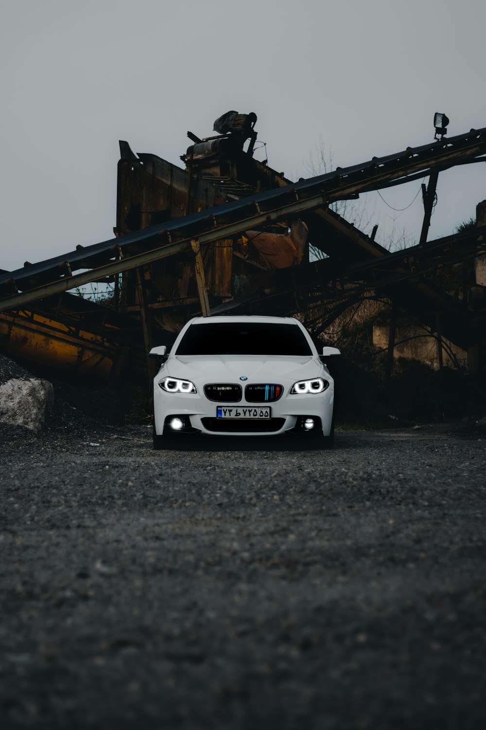 a white car parked in front of a pile of rubble