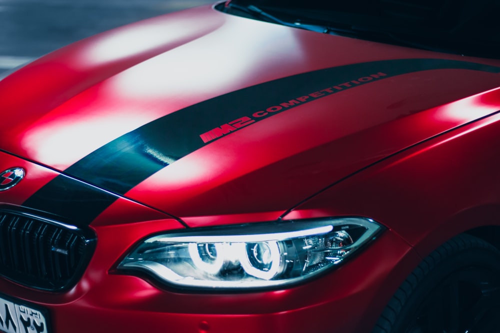 a close up of a red car with a black stripe