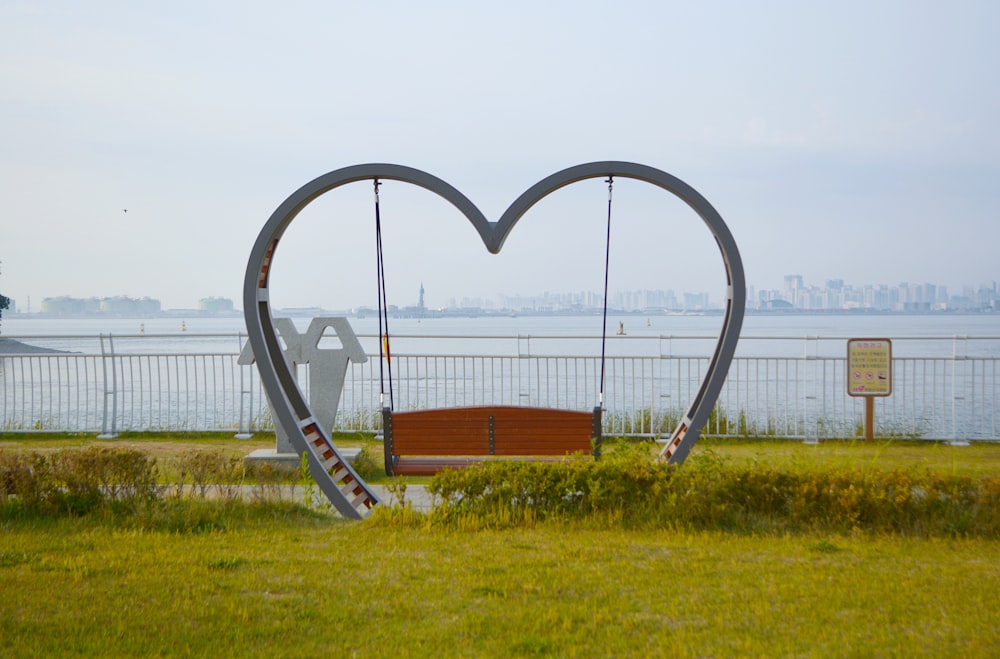 a heart shaped sculpture in the middle of a field