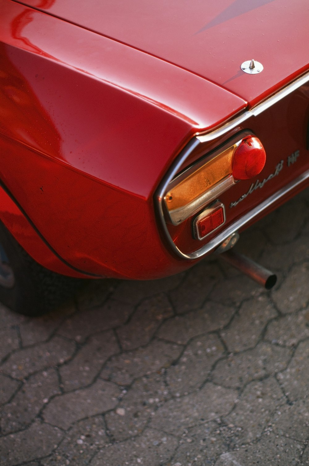 a close up of the tail end of a red car