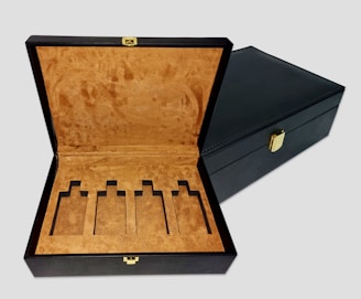 an open black box with a gold handle