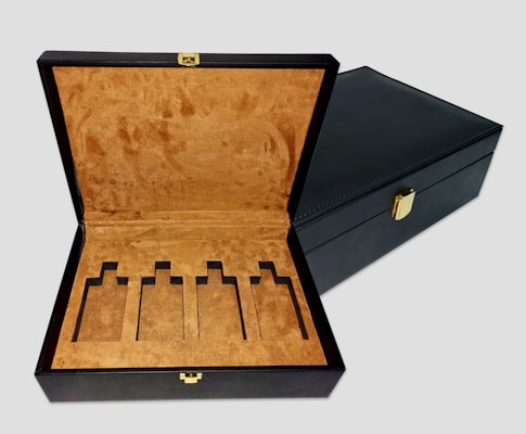 an open black box with a gold handle