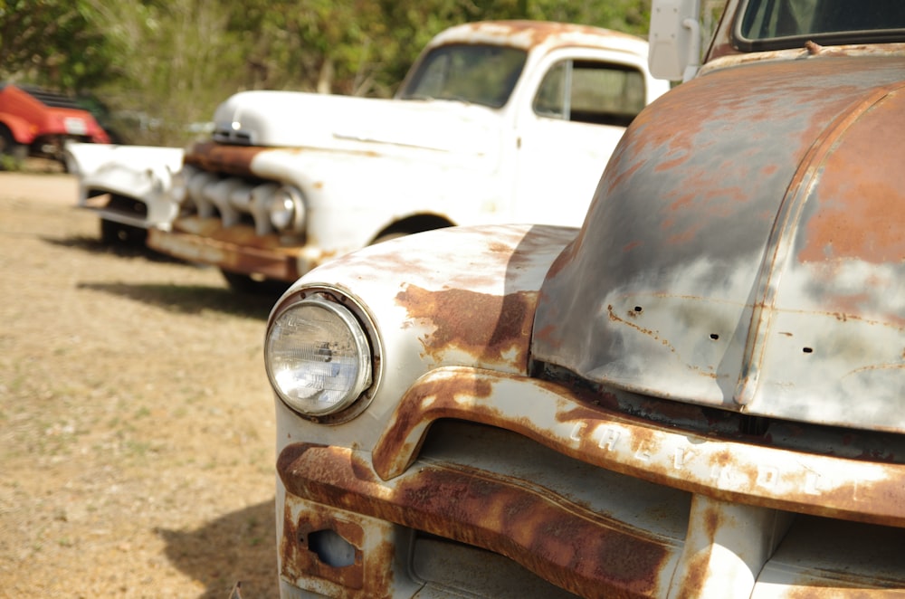 an old rusted truck sitting in a field