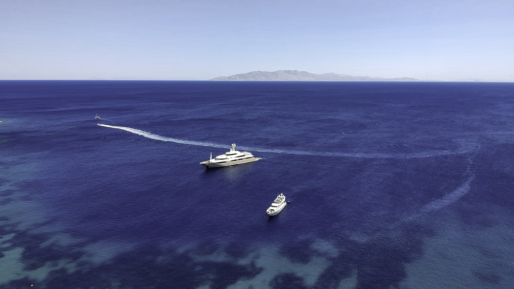 two boats in the water near a large boat