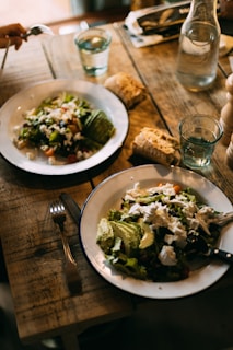 A cozy family dinner setup with simple dishes, bread, and glasses of water on a wooden dining table.