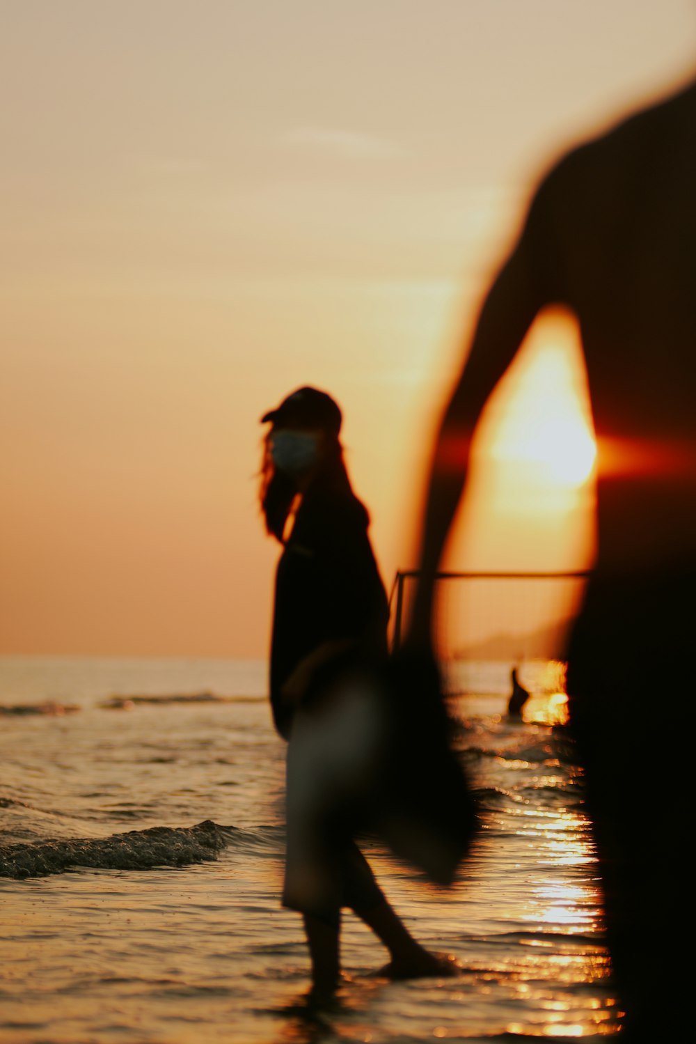 a person walking on the beach at sunset