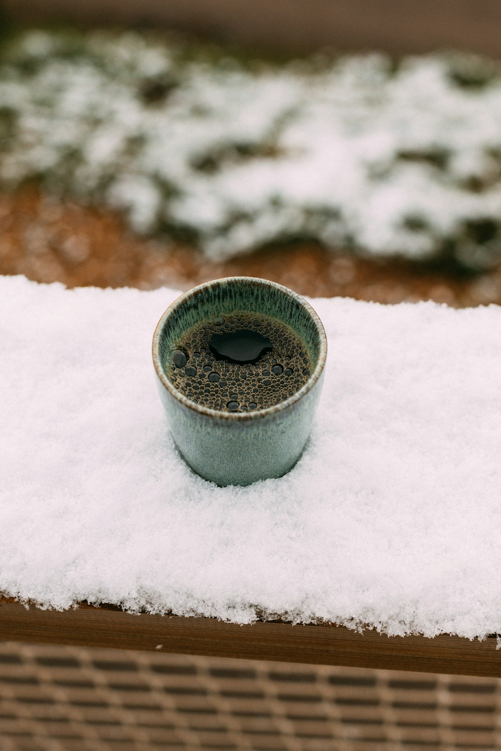 una piccola tazza seduta sopra un mucchio di neve