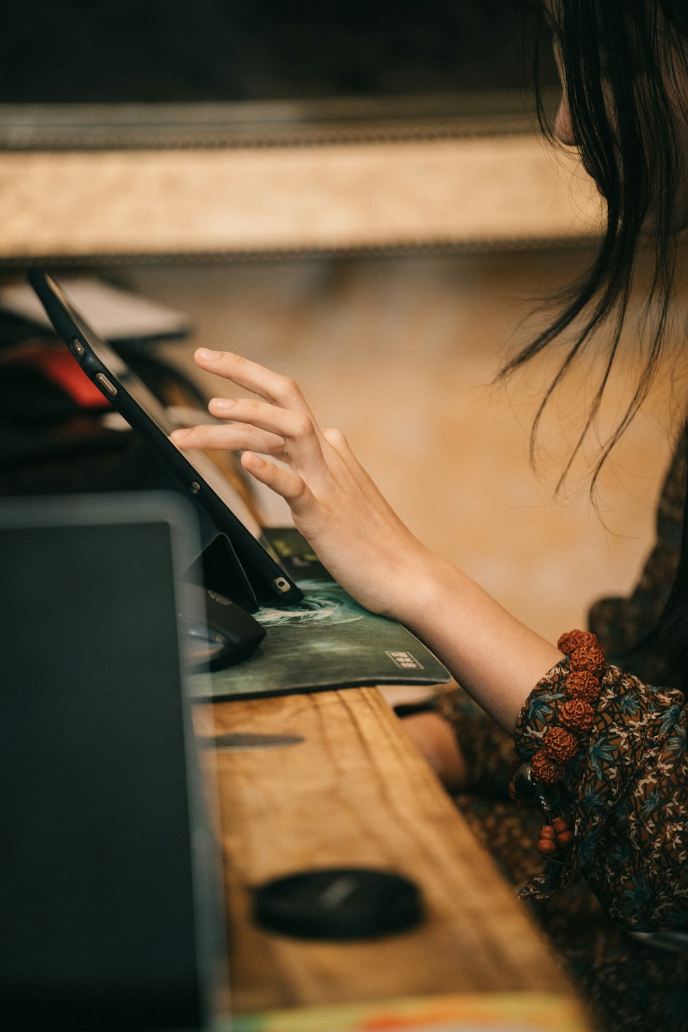 a woman sitting at a table using a laptop computer