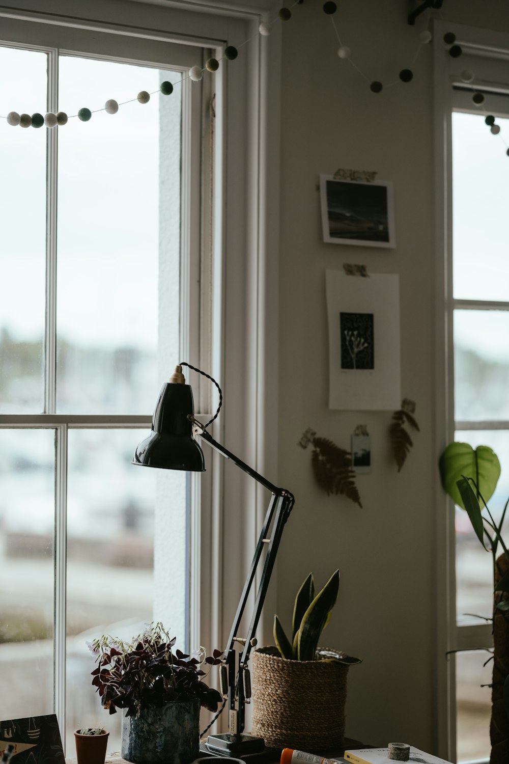 a desk with a lamp and a potted plant