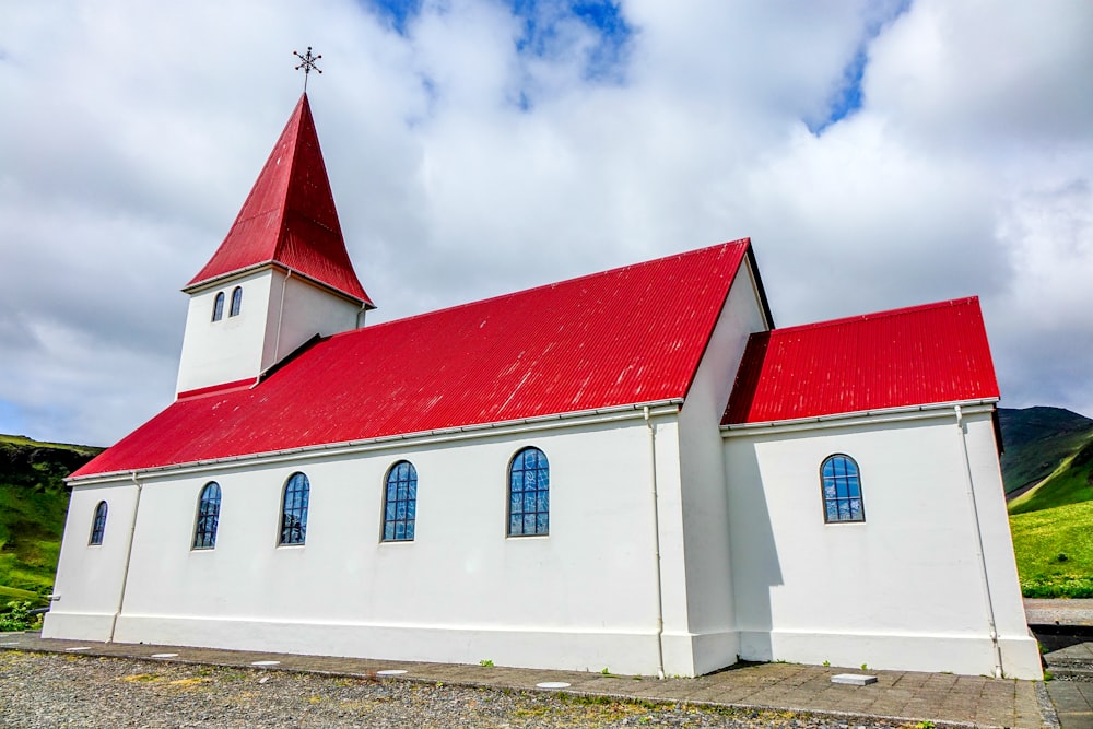 a white church with a red roof and steeple