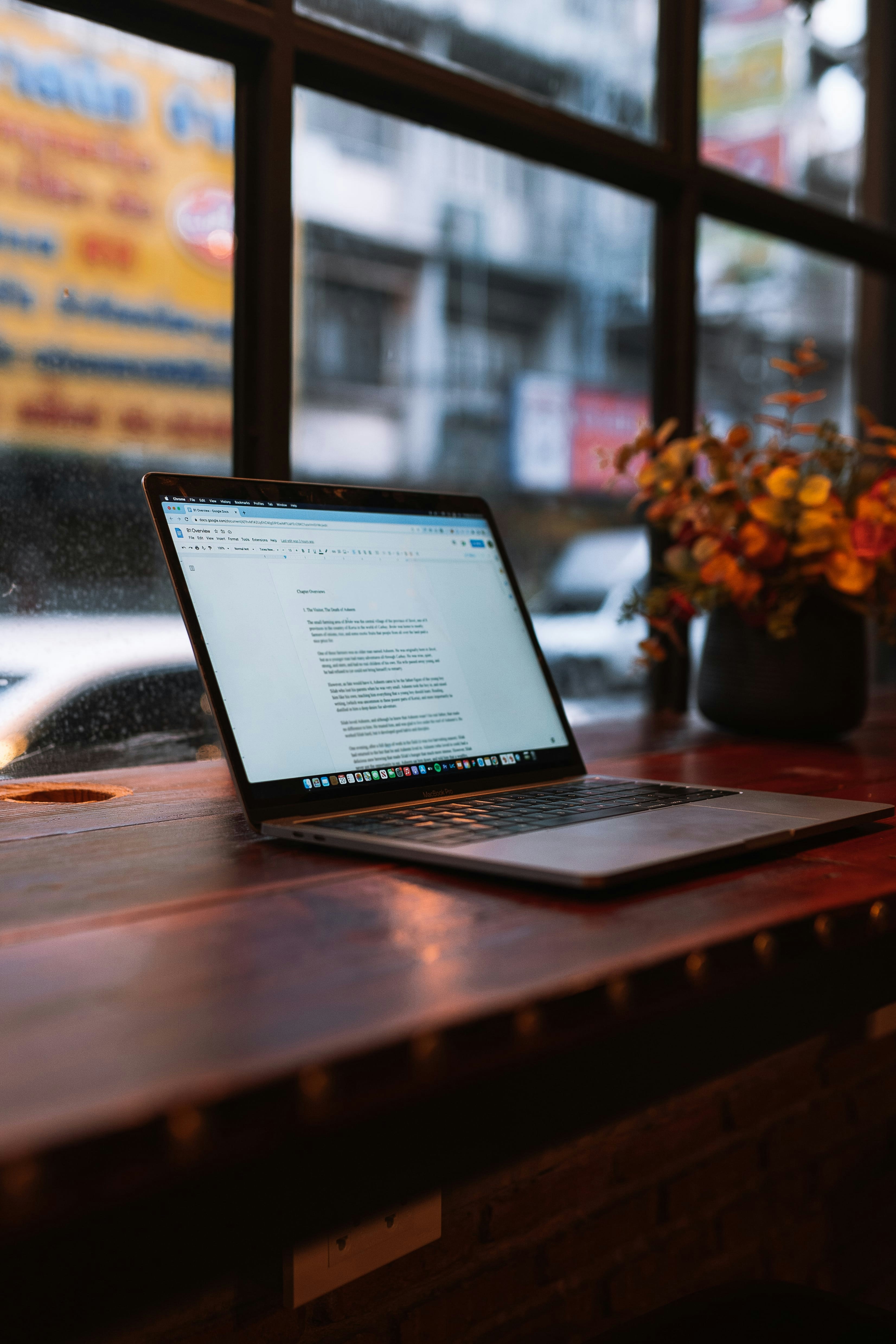 komputer laptop yang duduk di atas meja kayu