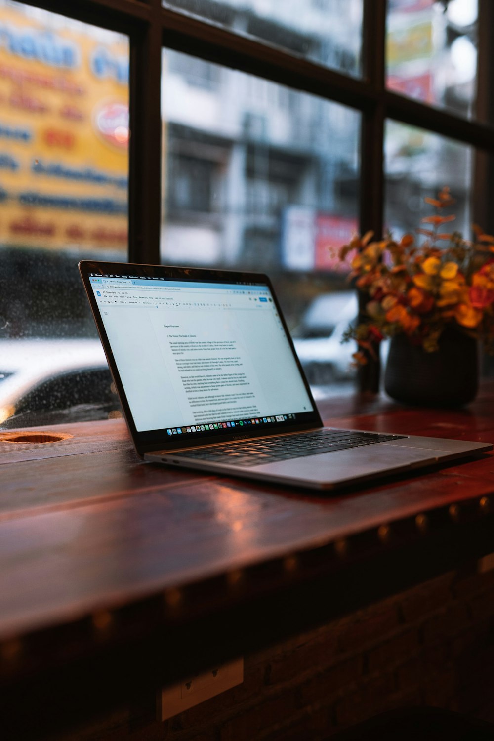 a laptop computer sitting on top of a wooden table