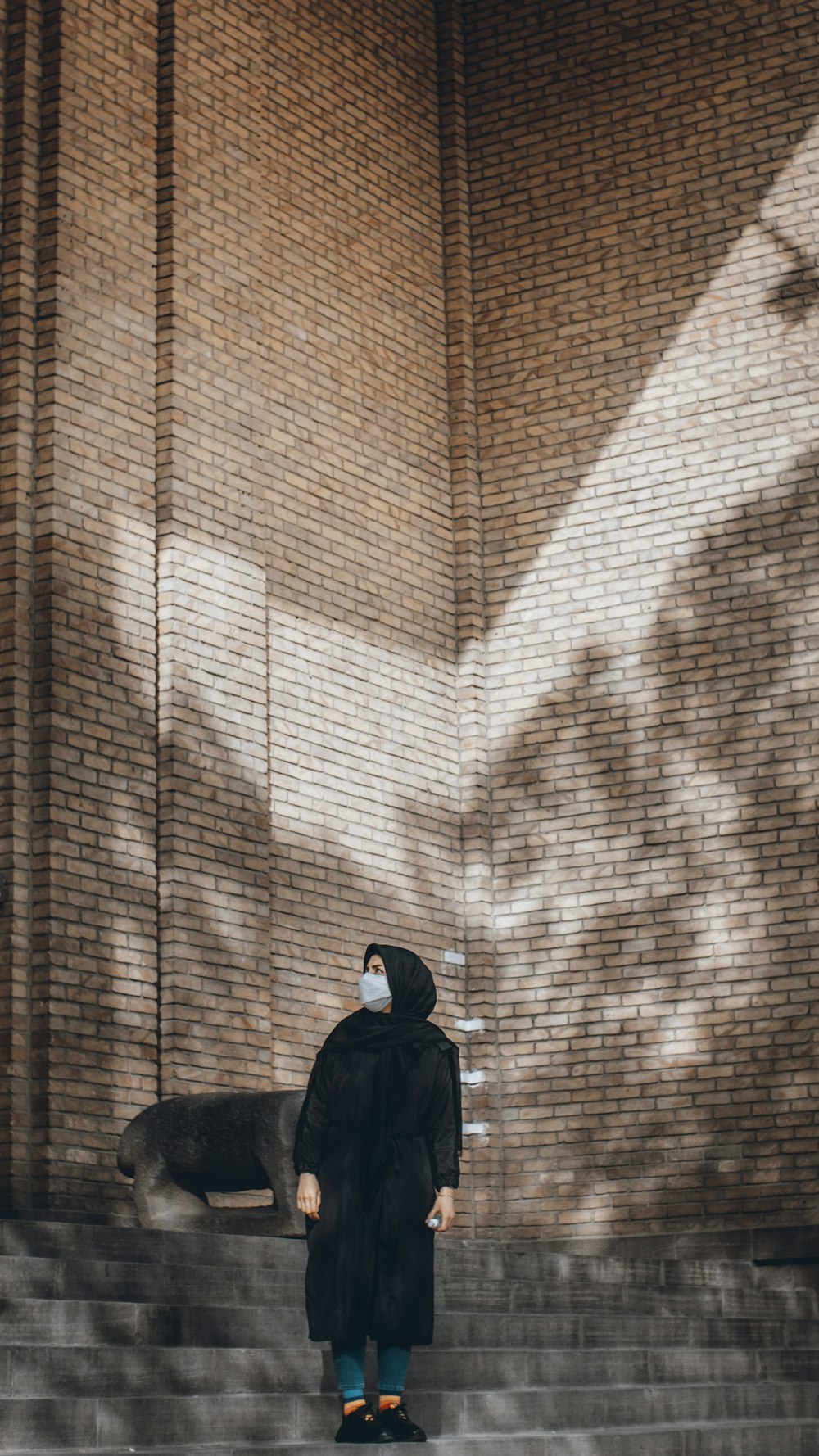 a person wearing a face mask standing on a set of stairs