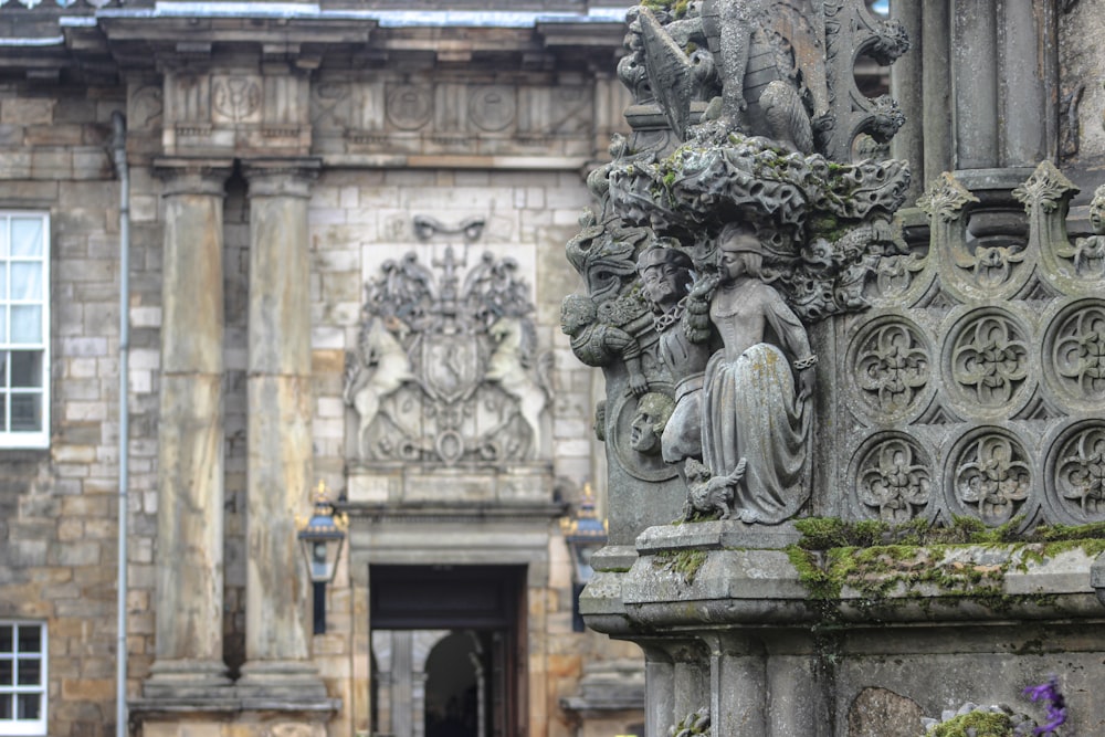 a statue of a woman sitting on top of a stone pillar