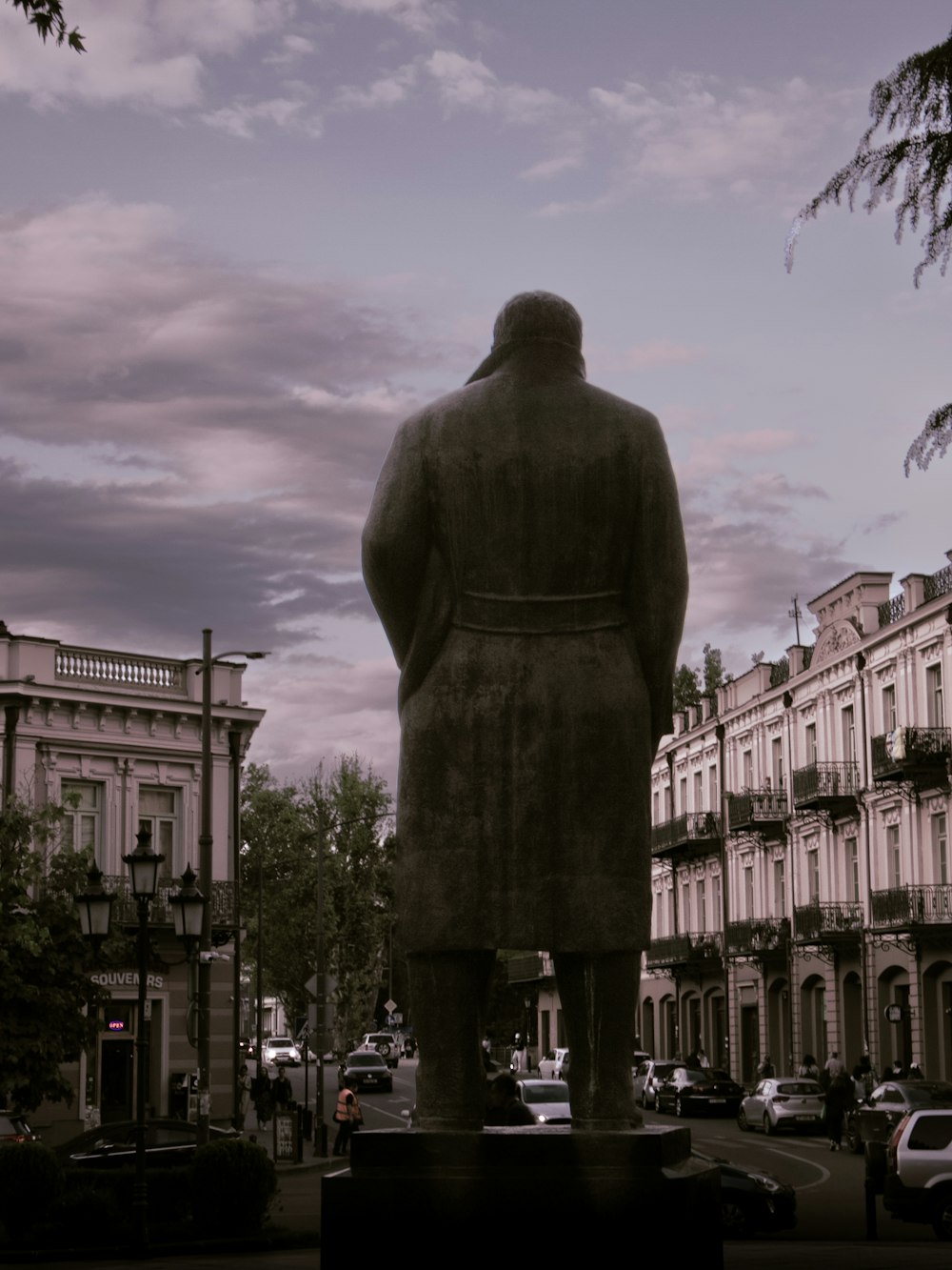a statue of a man standing in the middle of a street