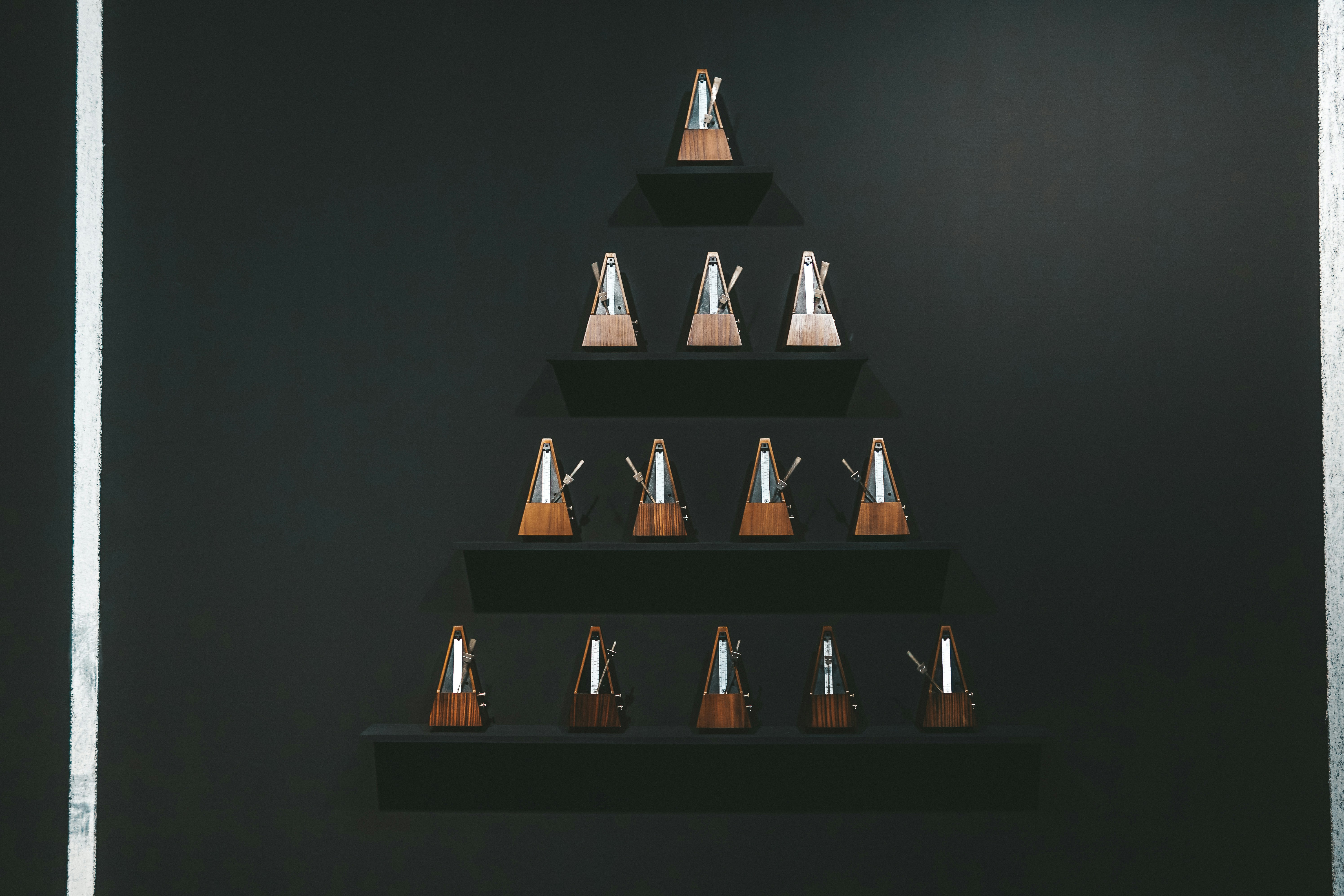 a black wall with a wooden shelf with a christmas tree on it