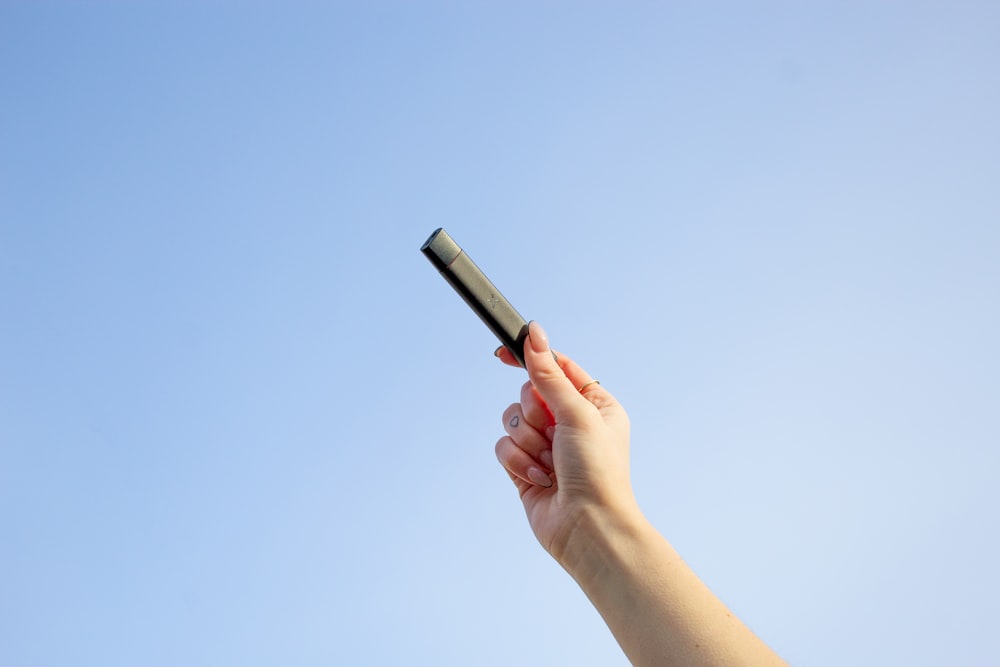 a person holding a cell phone up in the air