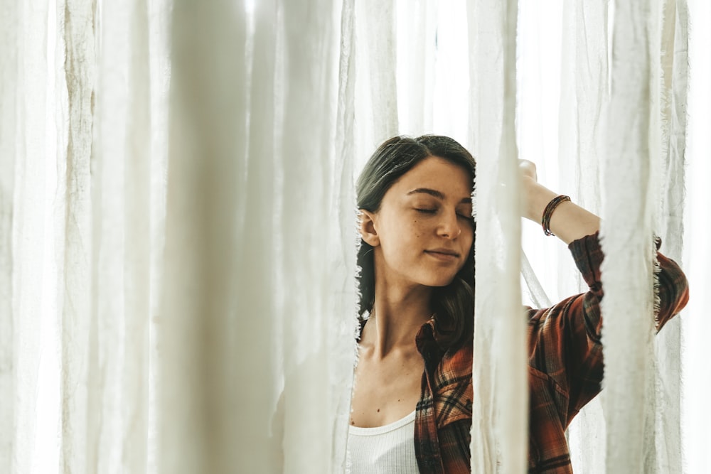 a woman looking out of a window with her eyes closed